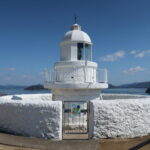 青空と海を背景に、真っ白い姿が美しい中ノ鼻灯台、見晴らしもいい