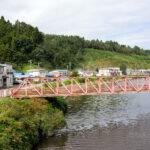 青森県鰺ヶ沢町の赤い橋と　大雨で運休続く五能線