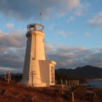 昇る朝日でオレンジ色に染まる佐木島灯台、頬が紅潮した子どものようだ