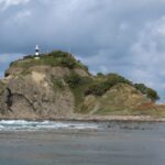 本目岬灯台を頭に乗せた巨大なサイが海に入っていく