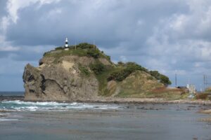 本目岬灯台を頭に乗せた巨大なサイが海に入っていく